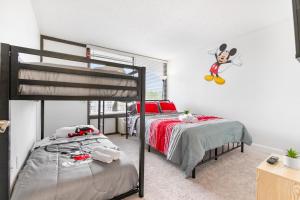 Un dormitorio con una litera con un ratón ratoncito en la pared en Mins from Disney Gym Pool Parking Pet Friendly, en Kissimmee