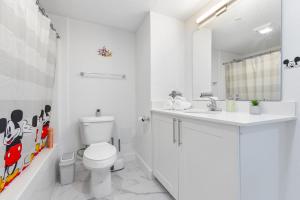 Un baño blanco con inodoro y lavabo. en Mins from Disney Gym Pool Parking Pet Friendly, en Kissimmee 22 fotos más