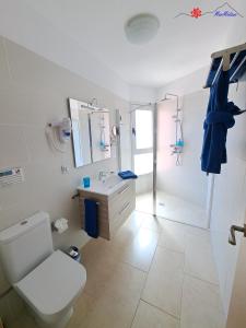 ein weißes Badezimmer mit Toilette und Waschbecken in der Unterkunft MarMédano Apartamento 2 in El Médano