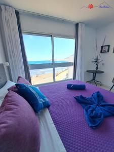 ein Schlafzimmer mit einem Bett mit Blick auf den Strand in der Unterkunft MarMédano Apartamento 2 in El Médano