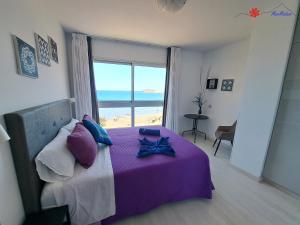 ein Schlafzimmer mit einem Bett mit Blick auf das Meer in der Unterkunft MarMédano Apartamento 2 in El Médano