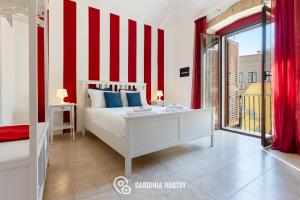 a bedroom with a bed with a red and white striped wall at Living Villanova Apartment in Cagliari