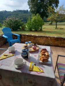 a table with food on it with a view of a field at Le chalet des Contries in Sarlat-la-Canéda