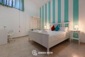 a bedroom with a bed and a desk and a chair at Living Villanova Apartment in Cagliari