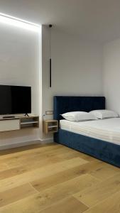 a bedroom with a bed and a flat screen tv at Tirana Central Apartments in Tirana