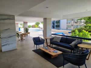 a living room with a couch and chairs and a pool at Atlantic City Apart in Salvador