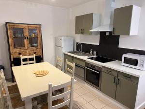 a kitchen with a table and a sink and a microwave at T3 Macon Centre Rambuteau in Mâcon +6 photos