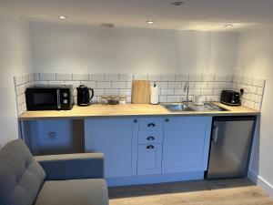 a kitchen with a counter with a microwave and a sink at UG Apartment in Bangor