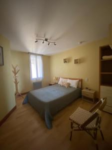 una camera da letto con un letto e una sedia di Sandrine a Cadours