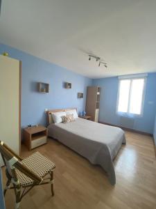 una camera da letto con un letto, una sedia e una finestra di Sandrine a Cadours