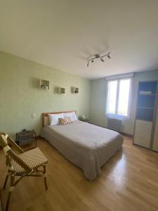 una camera da letto con un letto, una sedia e una finestra di Sandrine a Cadours