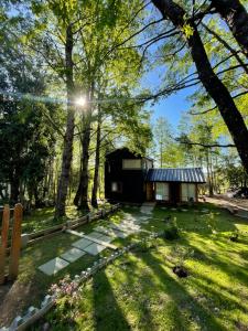 a house in the middle of a yard with trees at Daben Recinto Ñuble camino Termas de Chillan in Recinto
