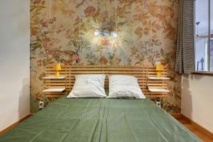 a bedroom with a green bed with floral wallpaper at Oiseaux du Paradis in Amélie-les-Bains-Palalda