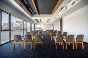 a conference room with chairs and tables and windows at Przystan Bydgoszcz in Bydgoszcz