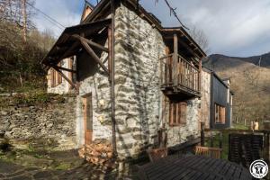 an old stone building with a balcony on it at L'Escale Pyrénéenne in Melles