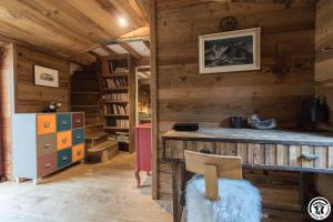 a room with a wooden wall with a table and a chair at L'Escale Pyrénéenne in Melles