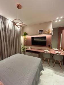 a bedroom with a bed and a desk with a television at Studio Sunset João Pessoa in João Pessoa +12 photos