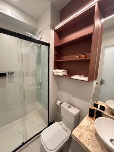 a bathroom with a toilet and a glass shower at Studio Sunset João Pessoa in João Pessoa