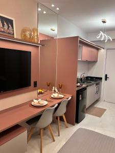 a kitchen with a table with chairs and a television at Studio Sunset João Pessoa in João Pessoa +12 photos