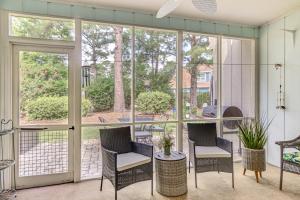 porche cubierto con sillas, mesa y ventanas en Patio and Pool Access North Myrtle Beach Retreat!, en Myrtle Beach