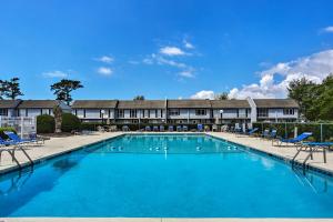 Una gran piscina con sillas y un edificio. en Patio and Pool Access North Myrtle Beach Retreat!, en Myrtle Beach