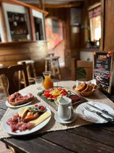 a wooden table with plates of food on it at London Hostel in Dabas +35 photos