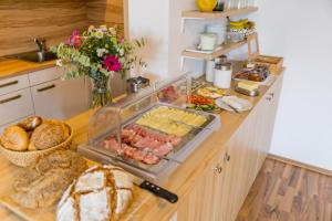 a kitchen counter with a tray of food and bread at Gästehaus Lackenblick in Illmitz