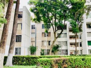 Un edificio de apartamentos con árboles en frente. en Rincón Coapa, en Ciudad de México