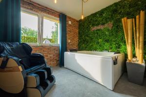 a bath tub in a room with a green wall at Private Baltic Spa & Art Suite in Dziwnów
