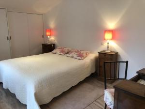 a bedroom with a bed with two lamps on it at La biche in Bonnes