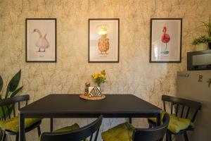 a table with pictures of birds on a wall at Private Baltic Spa & Art Suite in Dziwnów