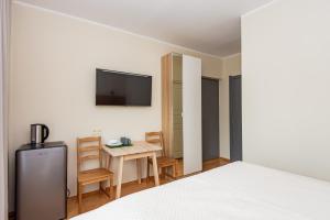 a bedroom with a bed and a table and a tv at Smilciu 34 in Palanga
