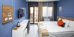 a bedroom with blue walls and a bed with orange pillows at Taksim Leon's Hotel in Istanbul