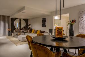 a living room with a table and a couch at Grand Spa-Francorchamps Villa - Chalourous "home sweat home" for Families, Friends & Pilots - Splendid 4-Bedroom with Home Cinema theater & pool in Spa +36 photos