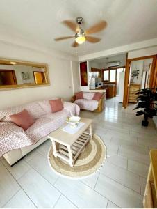 a living room with a couch and a table at APARTAMENTOS ROSI - 5-10 Minute Walk To La Zenia Beach, Sea View, Beach Bar, Cliff Walk, Shops, Paddys Point, Cabo Roig - Free fast Fibre Optic Broadband, Free Parking, Tassimo coffee machine, TV Firestick compatible in Playas de Orihuela