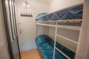 a small room with two bunk beds and a hallway at Charmant studio cabine in Cap d'Agde
