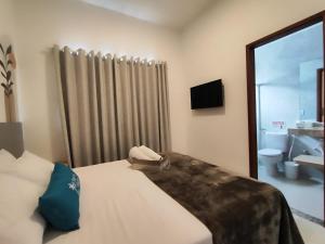 a bedroom with a bed and a window and a bathroom at Apartamento completo em Búzios in Búzios