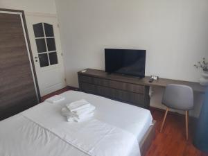 a bedroom with a bed with a desk and a television at Mari's By The Sea in Mangalia