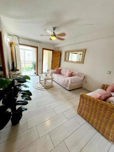 a living room with a couch and a ceiling fan at APARTAMENTOS ROSI - 5-10 Minute Walk To La Zenia Beach, Sea View, Beach Bar, Cliff Walk, Shops, Paddys Point, Cabo Roig - Free fast Fibre Optic Broadband, Free Parking, Tassimo coffee machine, TV Firestick compatible in Playas de Orihuela