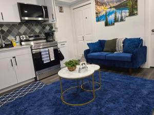 a living room with a blue couch and a table at Cozy New 1 bed basement suite in Edmonton