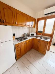 a kitchen with wooden cabinets and a white refrigerator at APARTAMENTOS ROSI - 5-10 Minute Walk To La Zenia Beach, Sea View, Beach Bar, Cliff Walk, Shops, Paddys Point, Cabo Roig - Free fast Fibre Optic Broadband, Free Parking, Tassimo coffee machine, TV Firestick compatible in Playas de Orihuela