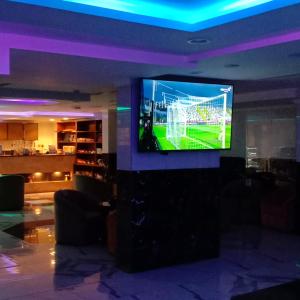 a tv in a room with a soccer game on it at فندق الاندلس الماسى in Al Madinah