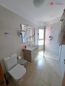 a white bathroom with a toilet and a sink at MarMédano Apartamento 3 in El Médano