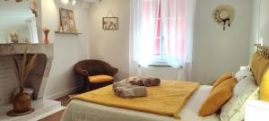 a bedroom with a bed with a fireplace and a table at Blois City - Le Petit Louis XII in Blois