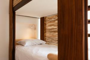 a bedroom with a bed with a wooden head board at SUUT Hostal Boutique in Playa del Carmen +40 photos