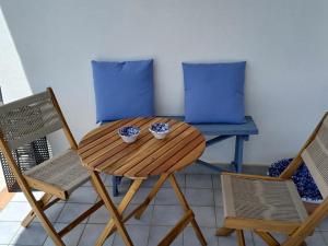 un tavolo di legno e sedie con due ciotole sopra di Fin Fiori a Menfi Altre 34 foto