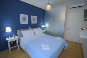 a bedroom with a white bed and a blue wall at Acropolis Hill House in Athens