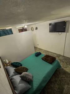 a room with a bed with pillows and a tv at Casa San Bartolo in Antigua Guatemala