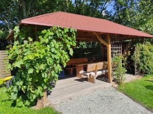 a gazebo with a bench in a garden at Wiśniowy Sad in Kudowa-Zdrój
