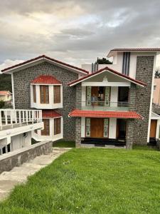 a house with a green lawn in front of it at Ecstatic Stay - Beautiful 2BHK Cottage, Resort, Villa, HomeStay in Kodaikanal in Kodaikānāl